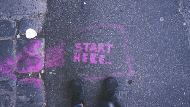 foto waar op het asfalt staat geschreven:'start here'